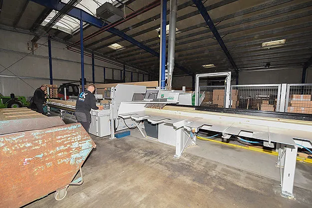 An employee at the sawing line in the hall.