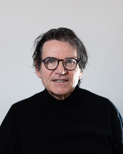 Me Alain Lorang, avocat à la cour: grey hair, round glasses, black polo neck.